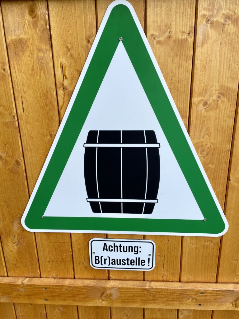 An der Strandveranda hängt ein Hinweisschild mit dem Text "Achtung B(r)austelle!)
